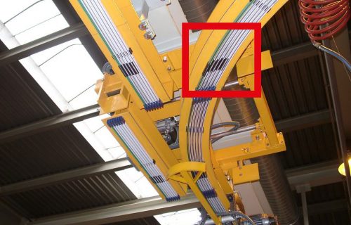 Rails électriques pour l’alimentation en puissance et contrôle d’un convoyeur aérien sur monorail HEA avec vu d’un aiguillage.